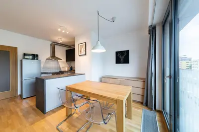 a kitchen and dining room with a wooden table at Garden Towers Apartments in Prague