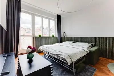 a bedroom with a bed and a large window at Apartment Petrska in Prague