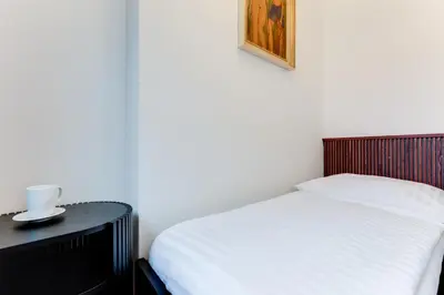 a bedroom with a white bed and a black table at Apartment Petrska in Prague