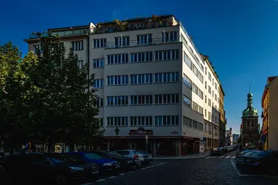 a tall white building with cars parked in front of it at Apartment Petrska in Prague