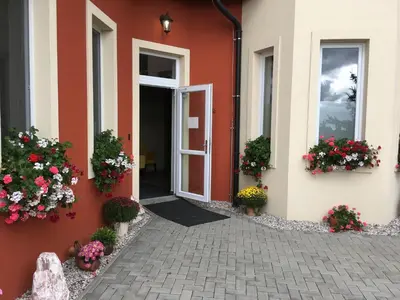 an open door to a building with flowers on it at Penzion v Zálesí in Mladá Boleslav