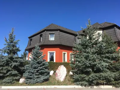 a red house with trees in front of it at Penzion v Zálesí in Mladá Boleslav