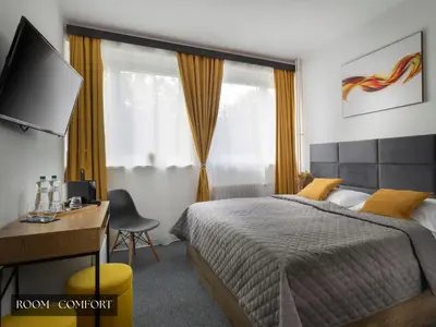 a bedroom with a bed and a desk and a television at Hotel AMITY in Prague