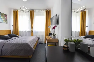 a bedroom with two beds and a table and a tv at Hotel AMITY in Prague