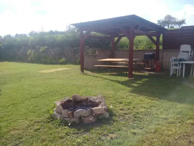 a fire pit in a yard with a gazebo at Chata u rybníka in Mšecké Žehrovice