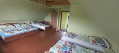 two beds in a room with wooden floors at Chata u rybníka in Mšecké Žehrovice