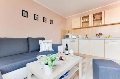 a living room with a blue couch and a table at Jane's Attic Apartment in Prague