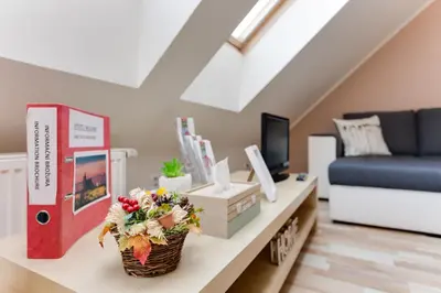 a living room with a table with flowers on it at Jane's Attic Apartment in Prague