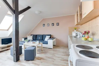a kitchen and a living room with a couch at Jane's Attic Apartment in Prague