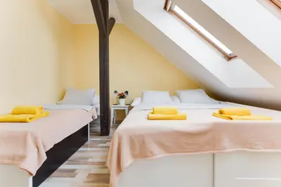two beds in a room with yellow pillows on them at Jane's Attic Apartment in Prague