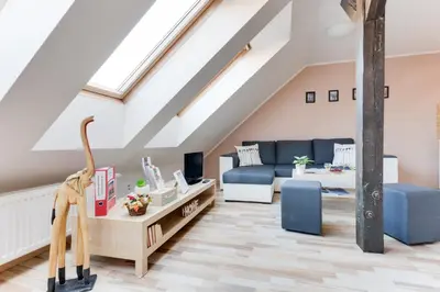 a attic living room with a couch and a table at Jane's Attic Apartment in Prague