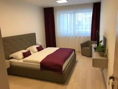 a bedroom with a bed and a large window at Rezidence Muzeum in Prague