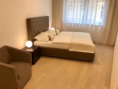a bedroom with a bed with a chair and a window at Rezidence Muzeum in Prague