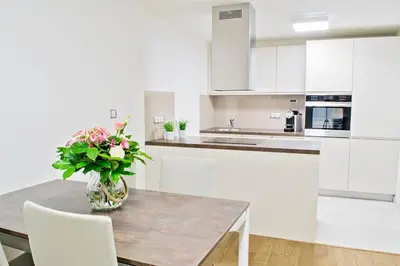a kitchen with a table with a vase of flowers on it at Rezidence Muzeum in Prague
