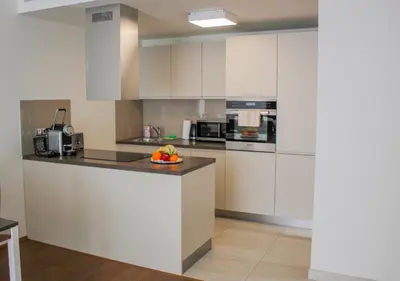 a kitchen with white cabinets and a bowl of fruit on a counter at Rezidence Muzeum in Prague