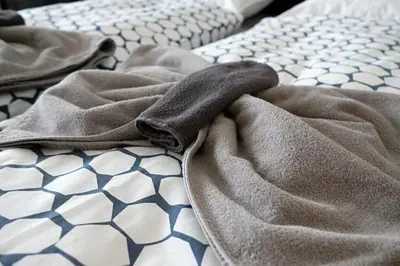 a blanket laying on top of a bed at Pawlansky Prague Apartments in Prague