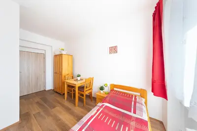 a bedroom with a bed and a table in a room at Penziony Beneš in Prague