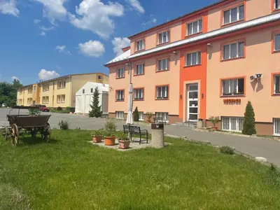 a building with a grassy yard with a picnic table and benches at Penziony Beneš in Prague