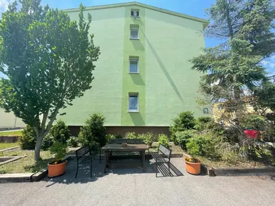 a green building with a picnic table in front of it at Penziony Beneš in Prague