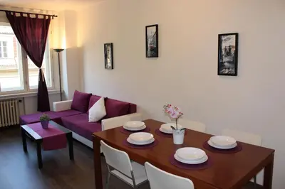 a living room with a table and a purple couch at Go Native Prague Apartment in Prague