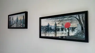 two framed pictures on a wall with a red umbrella at Go Native Prague Apartment in Prague