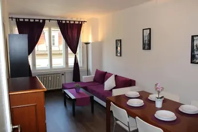 a living room with a purple couch and a table at Go Native Prague Apartment in Prague