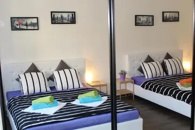 a bedroom with two beds and a mirror at Go Native Prague Apartment in Prague