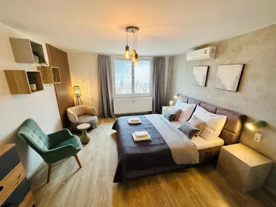a room with a bed and a couch and a chair at Beautiful Apartment Dlouhá in Prague