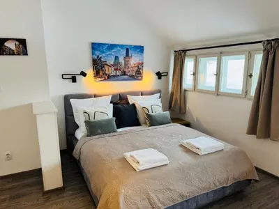 a bedroom with a large bed with two towels on it at Beautiful Apartment Dlouhá in Prague