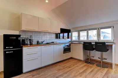 a kitchen with white cabinets and black appliances at Beautiful Apartment Dlouhá in Prague