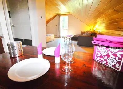 a wooden table with white plates and wine glasses on it at Apartments Zbraslav in Prague