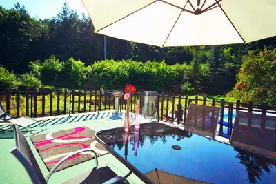 a table with an umbrella next to a swimming pool at Apartments Zbraslav in Prague