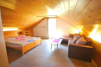 a bedroom with a bed and a couch in a room at Apartments Zbraslav in Prague