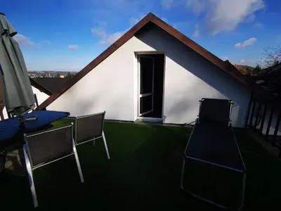 a house with chairs and a table and an umbrella at Apartments Zbraslav in Prague