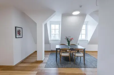 a dining room with white walls and a table and chairs at Harrachovsky Palace in Prague