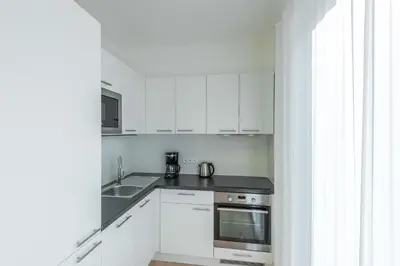 a white kitchen with a stove and a sink at Harrachovsky Palace in Prague