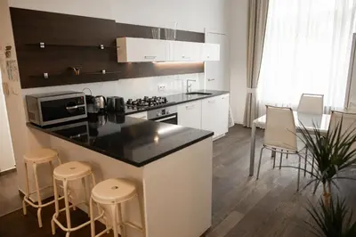 a kitchen with a counter and stools in a room at Luxury Modern Designed Oldtown Apartment in Prague