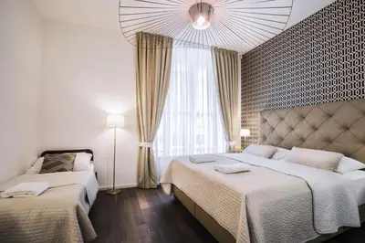 a bedroom with two beds and a large window at Luxury Modern Designed Oldtown Apartment in Prague