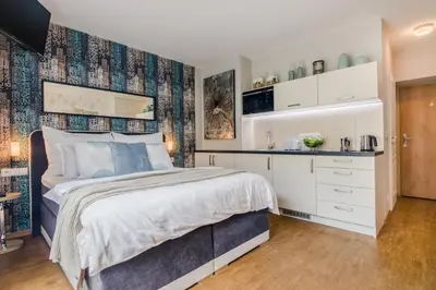 a bedroom with a bed and a desk and a window at AIR CONDITIONED Terrace Apartment Prague in Prague