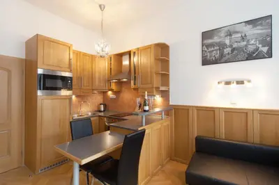 a kitchen with wooden cabinets and a table in it at Old Town Melantrichova Apartment in Prague