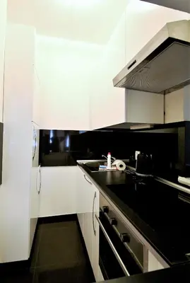 a kitchen with white cabinets and a black counter top at Residence Salvator - by Prague City Apartments in Prague
