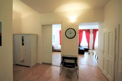 a room with a clock on the wall and a chair at Residence Salvator - by Prague City Apartments in Prague