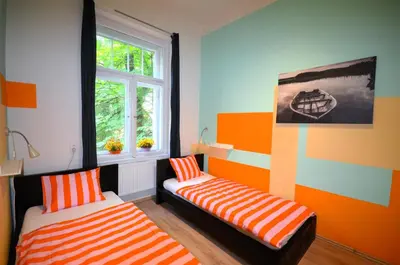 a colorful room with two beds and a window at Travel&Joy backpackers in Prague