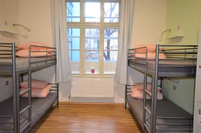 a room with three bunk beds and a window at Travel&Joy backpackers in Prague