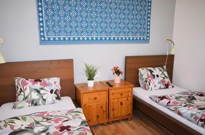 a room with two beds and a table with flowers on it at Travel&Joy backpackers in Prague