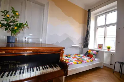 a piano sitting in a room next to a window at Travel&Joy backpackers in Prague