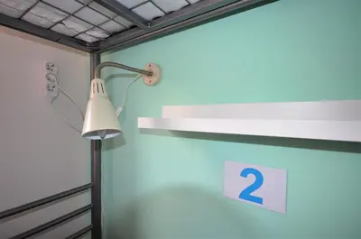a room with a lamp and a sign on a wall at Travel&Joy backpackers in Prague