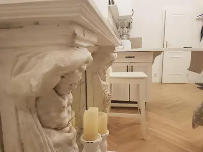 a statue of two women in a kitchen with a candle at Apartments With The Lions in Prague