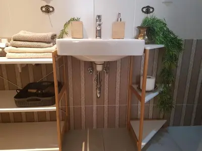 a bathroom with a white sink and shelves at Apartments With The Lions in Prague