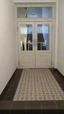 a pair of doors in a room with a tiled floor at Apartments With The Lions in Prague